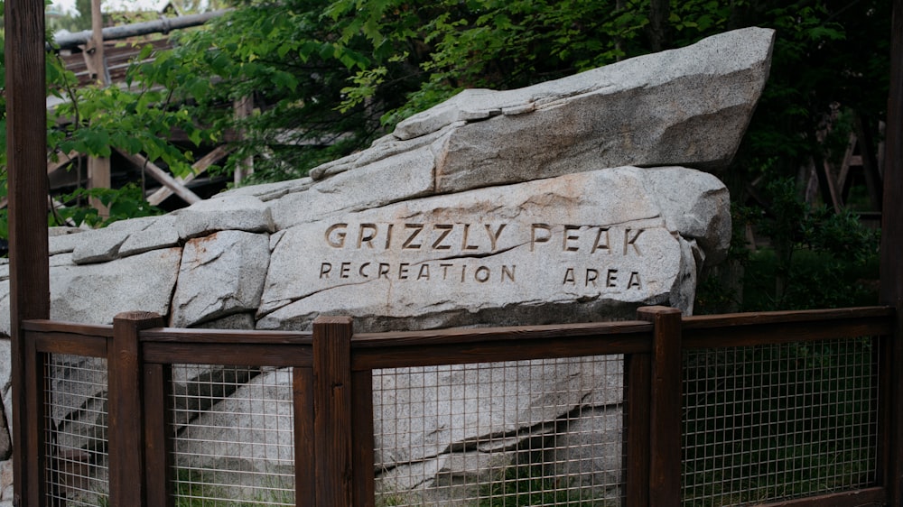 a large rock sitting on top of a wooden fence