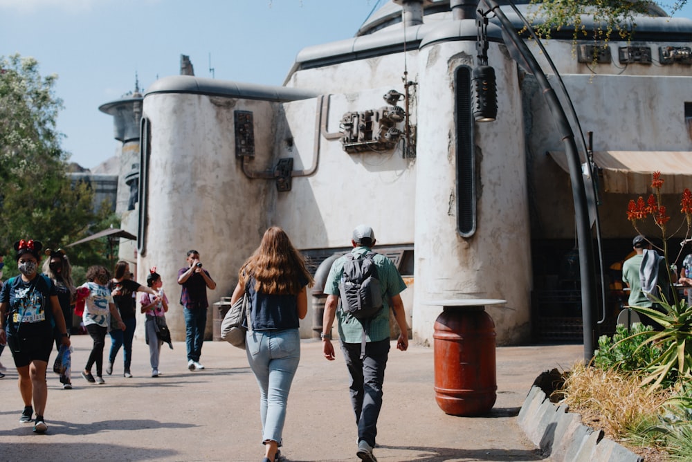 a group of people walking down a street next to a building