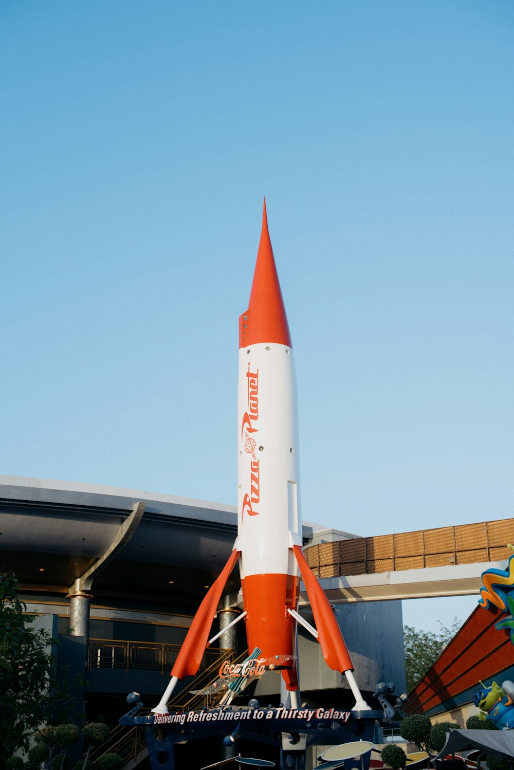 an orange and white rocket sitting on top of a building