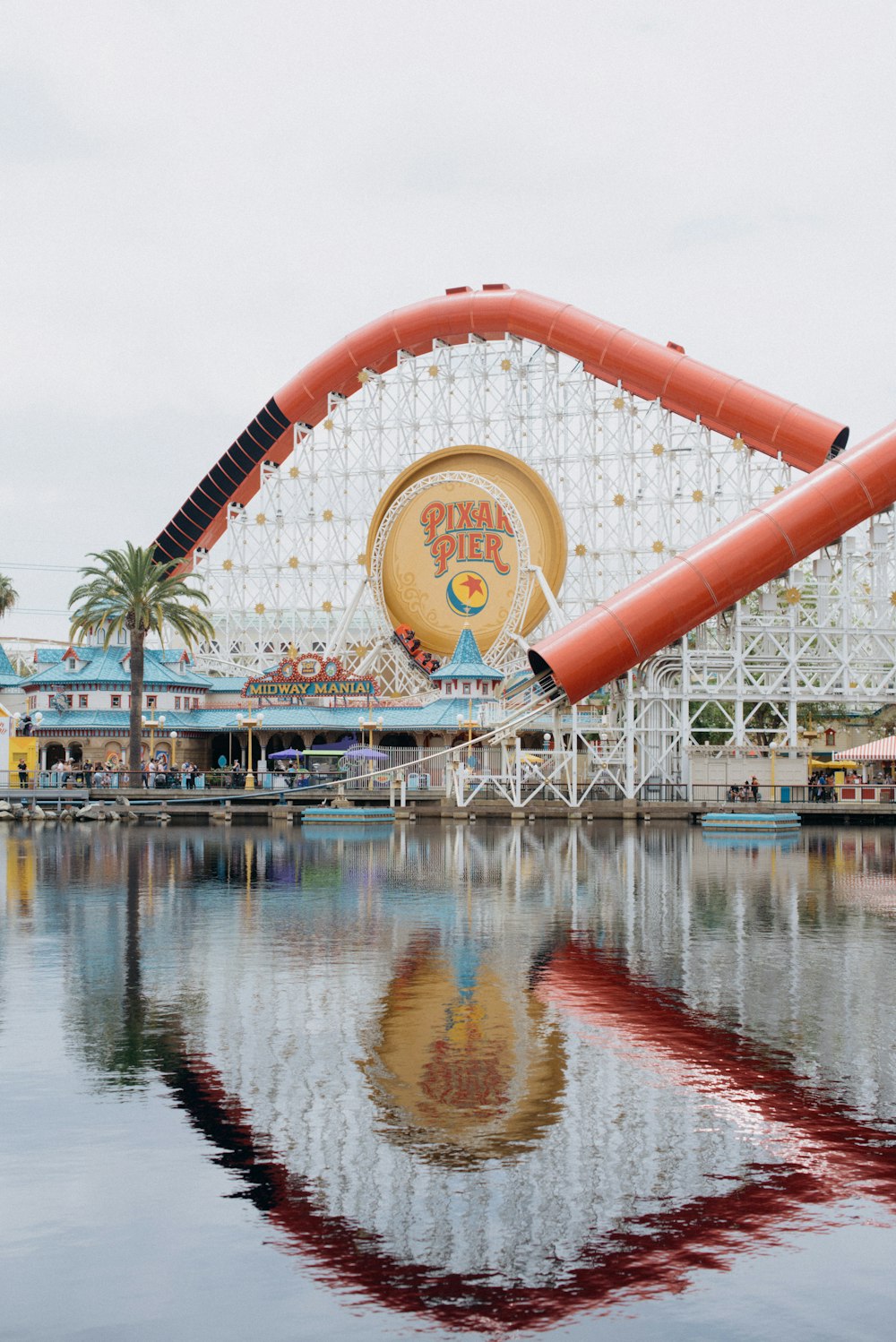 a roller coaster is reflected in the water