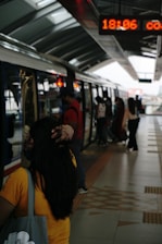 A group of customers entering a train from the platform. Rail customer experience