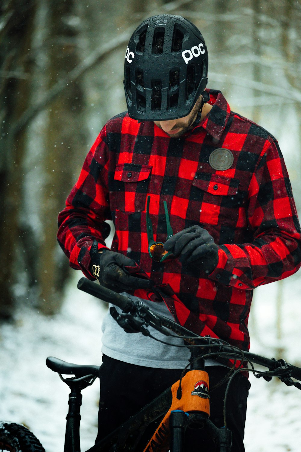 a man standing next to a bike in the snow