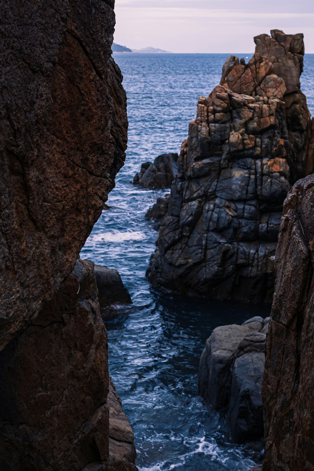 a person standing on a rock next to a body of water