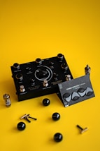 a pair of black ear plugs sitting on top of a yellow surface