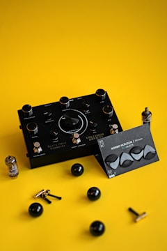 a pair of black ear plugs sitting on top of a yellow surface