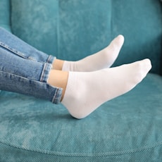 a woman sitting on a blue couch wearing white socks