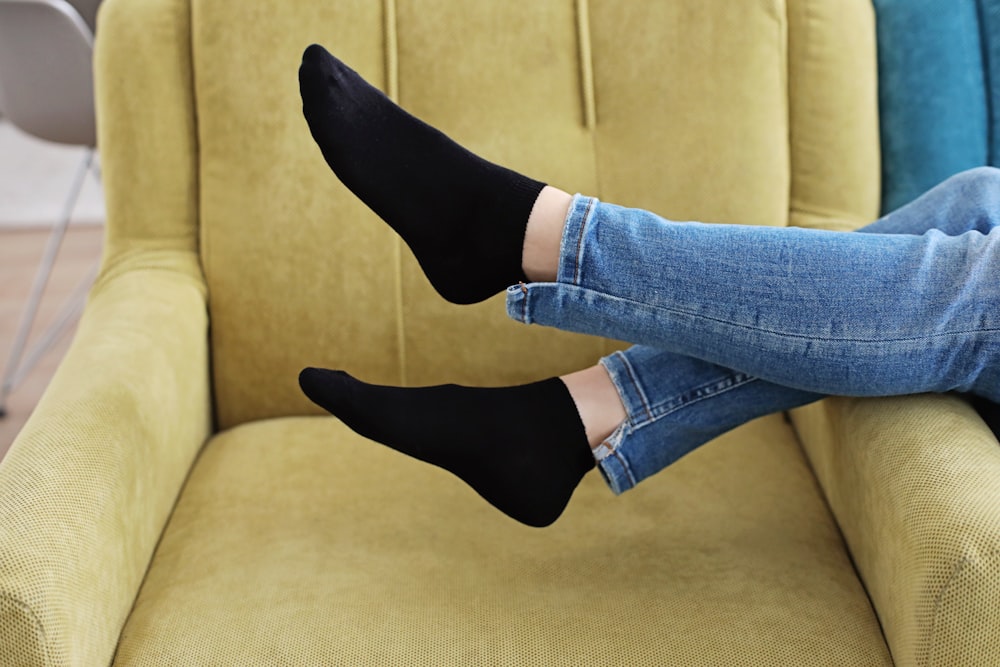 a woman sitting on a couch with her legs crossed