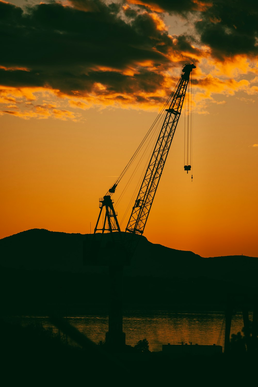 a crane is silhouetted against a sunset sky
