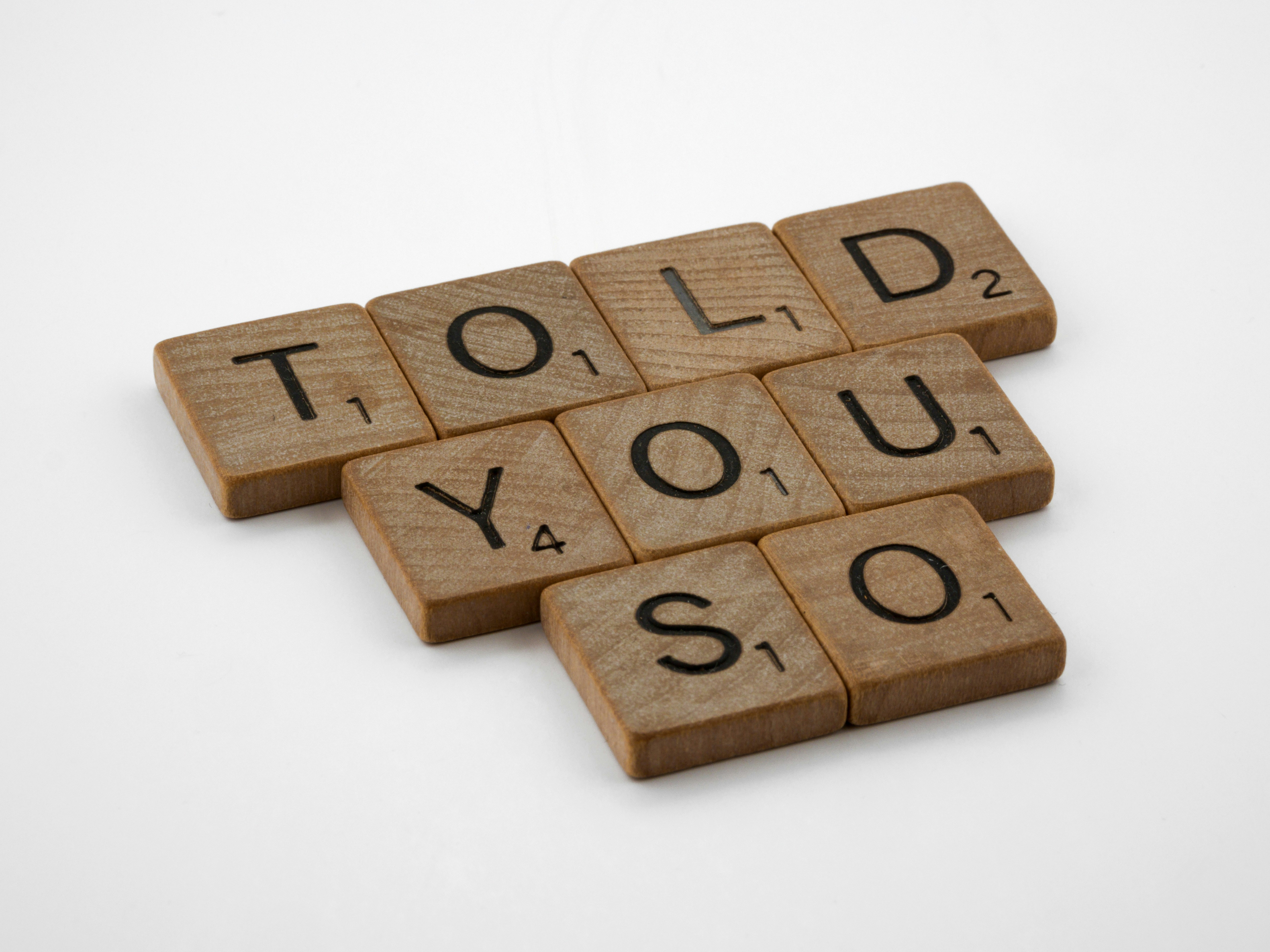 a scrabbled wooden block spelling the word told you so