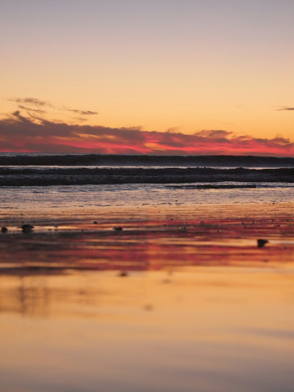 a person walking on the beach at sunset