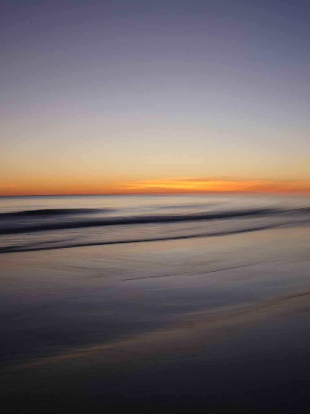 a blurry photo of a beach at sunset