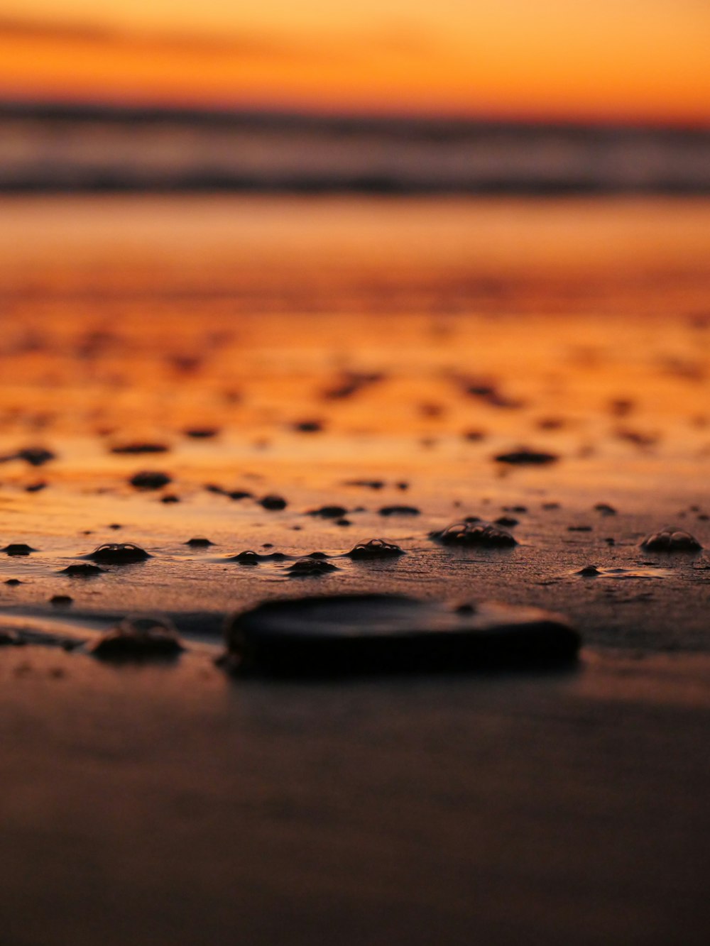 a close up of a cell phone laying on a beach