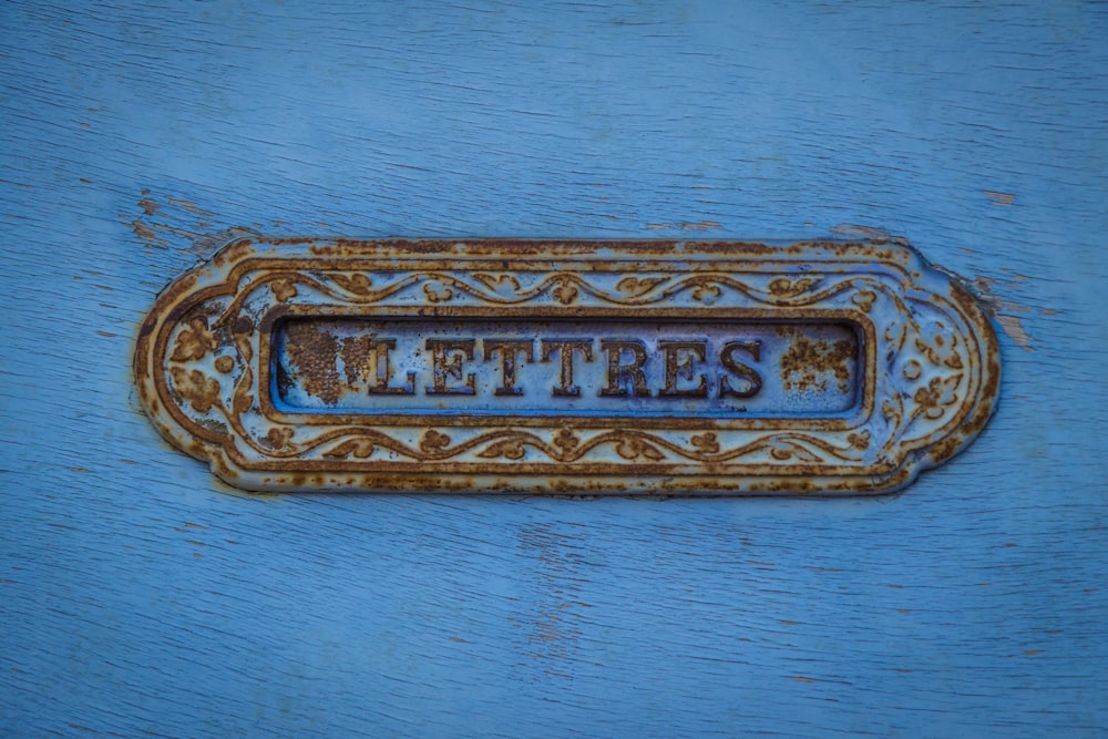 a rusted metal sign that says letters on it