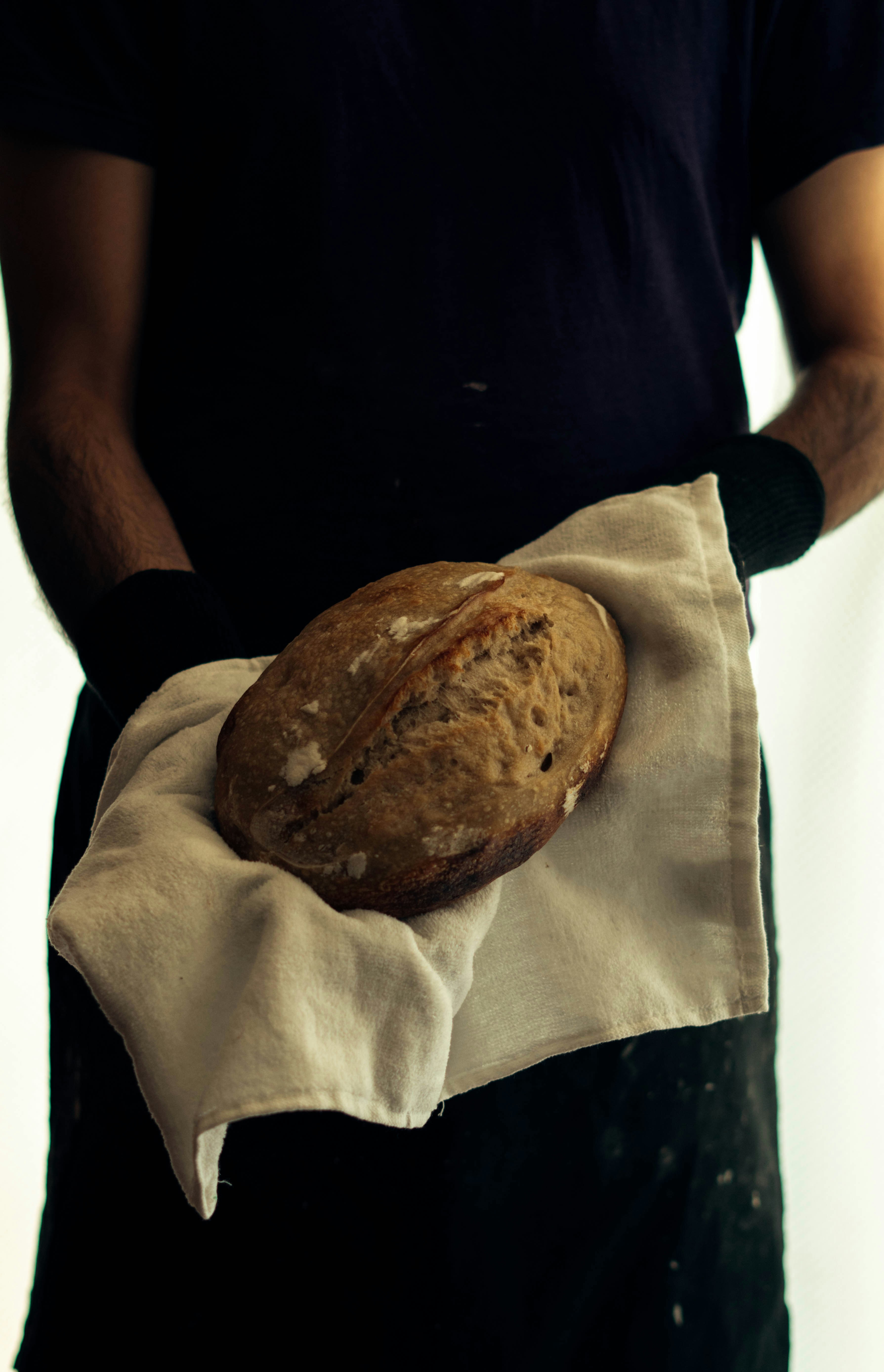 A smiling baker holding a tray of fresh croissants.