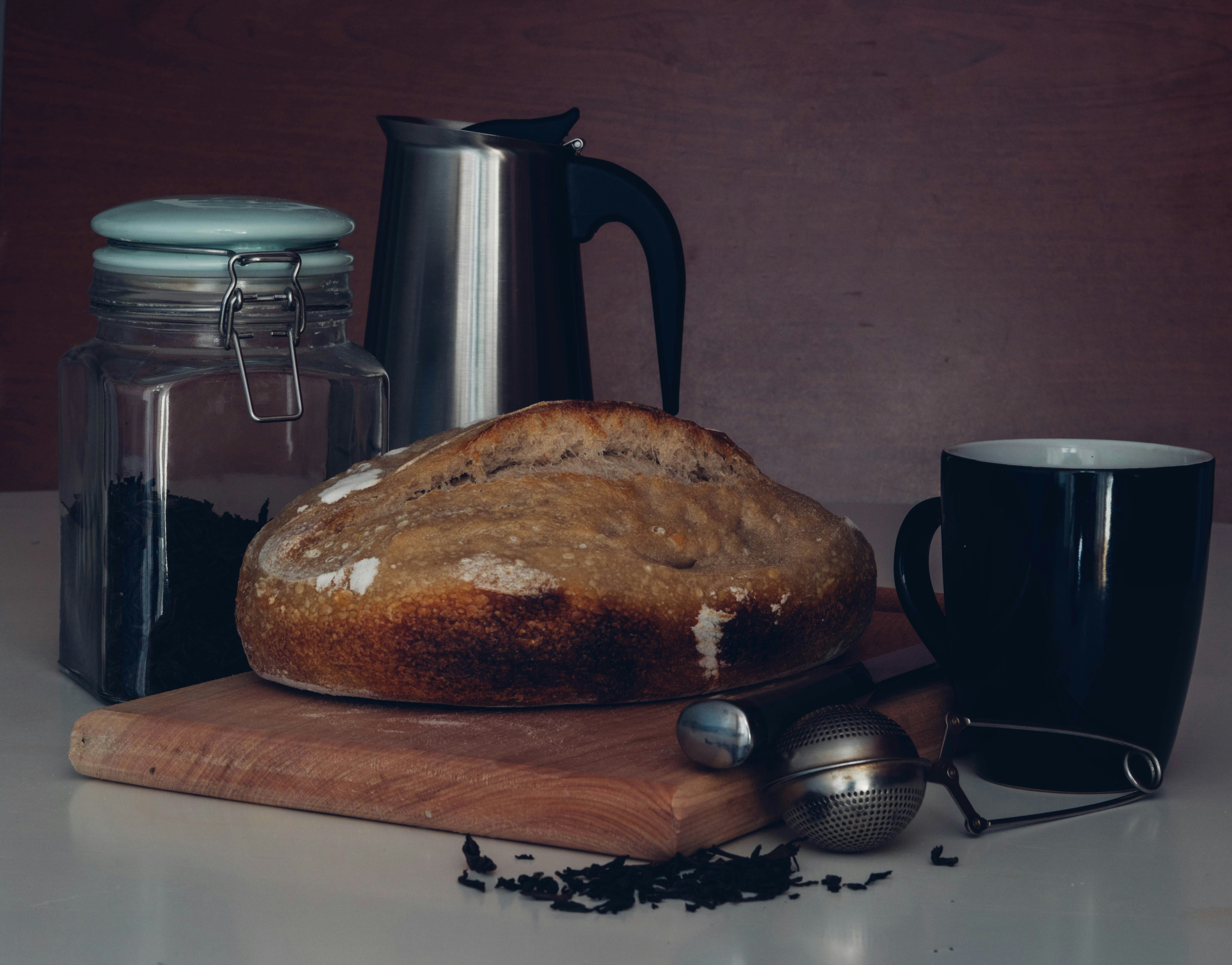 a loaf of bread sitting on top of a wooden cutting board, 