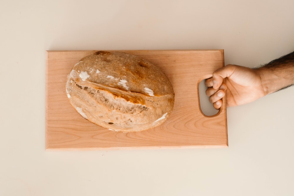 a loaf of bread sitting on top of a wooden cutting board