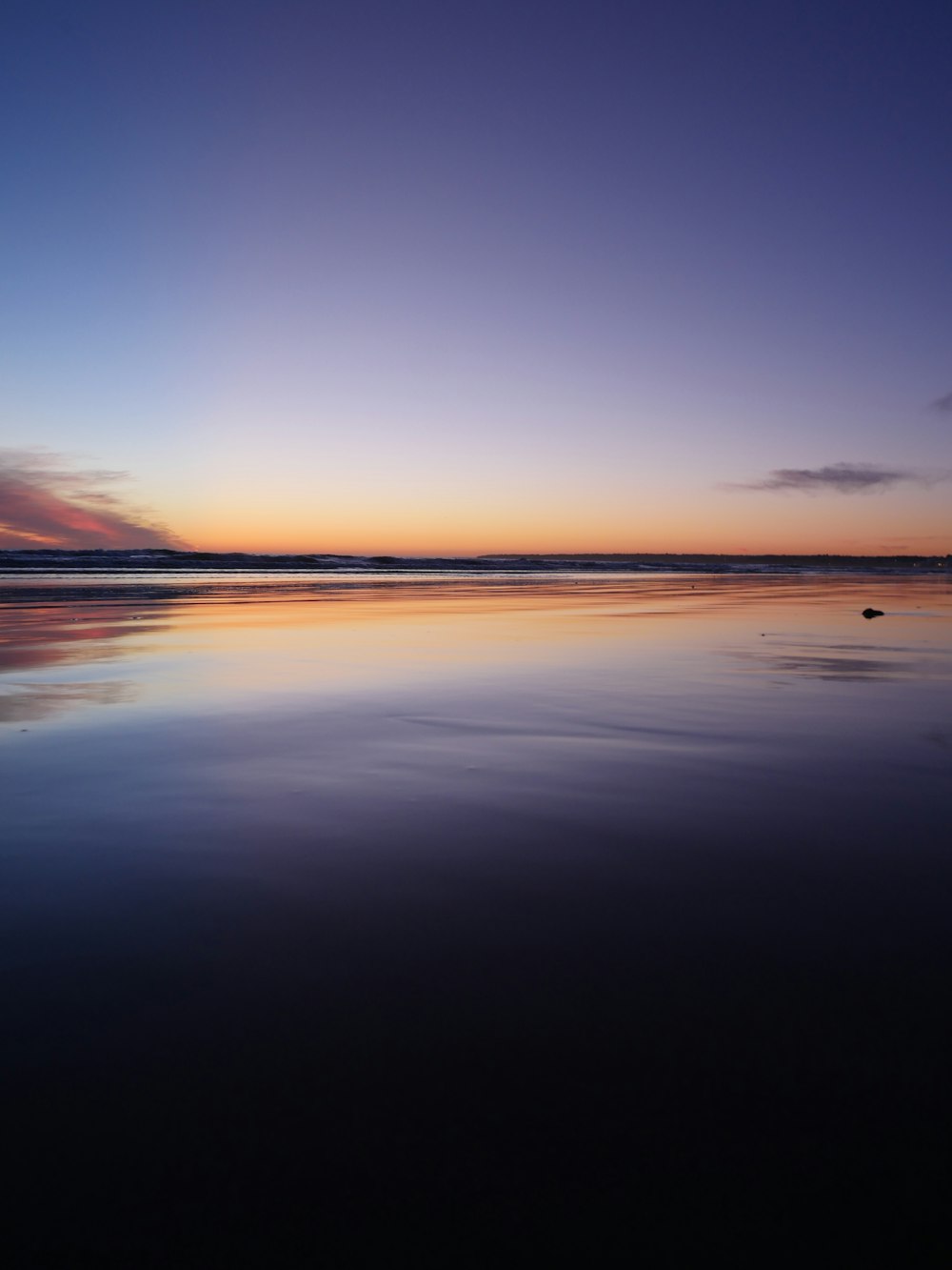 Le soleil se couche sur l’eau à la plage