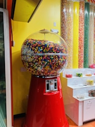a large gummy machine sitting in front of a yellow wall