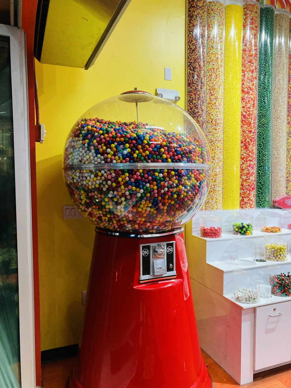 a large gummy machine sitting in front of a yellow wall