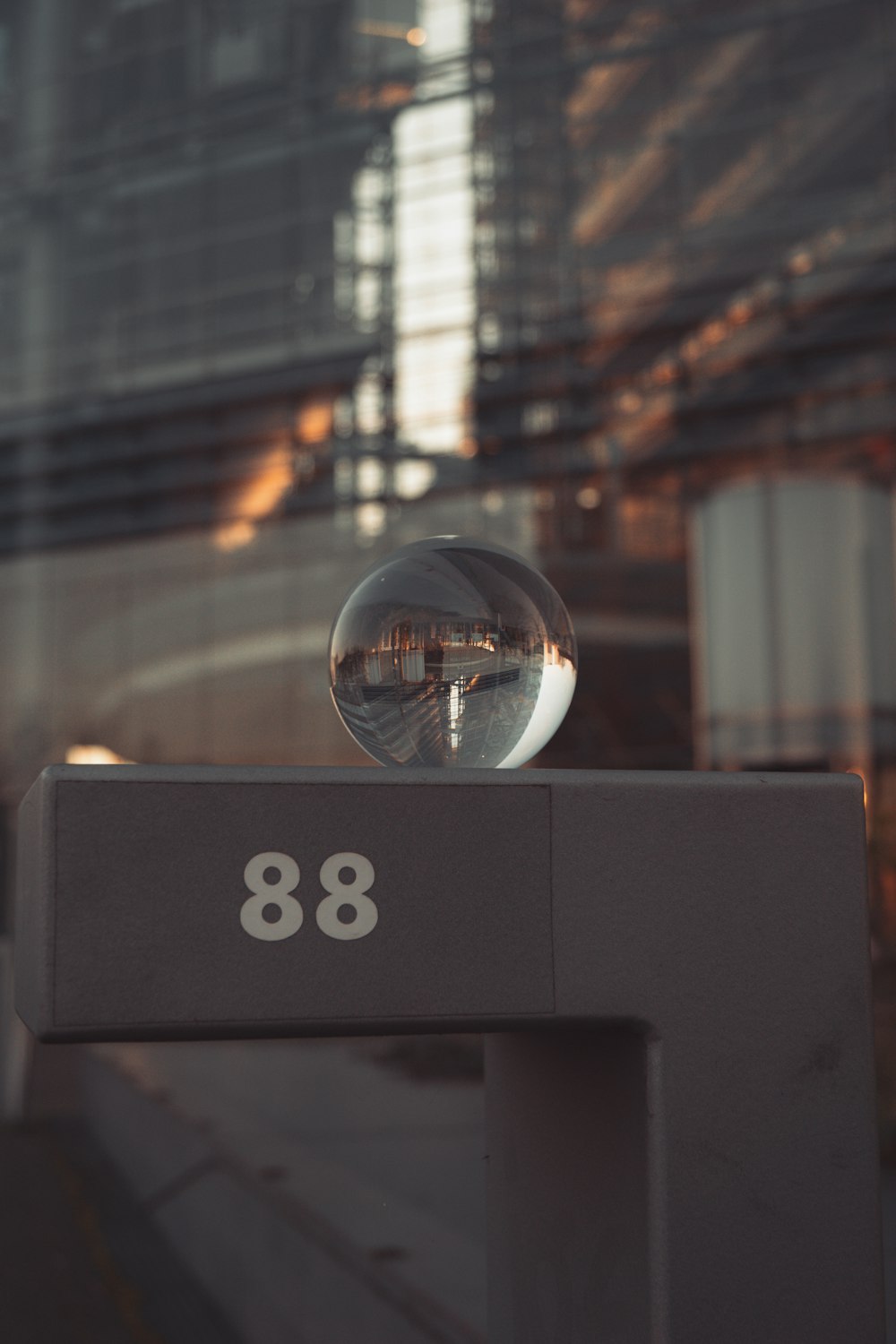 una palla di vetro seduta sopra un segno di metallo
