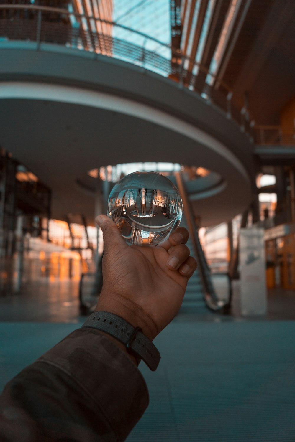 a hand holding a glass ball in front of a building