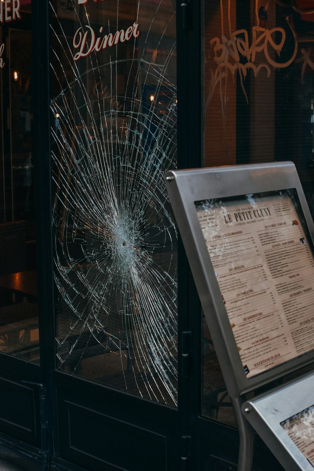a broken window in front of a restaurant