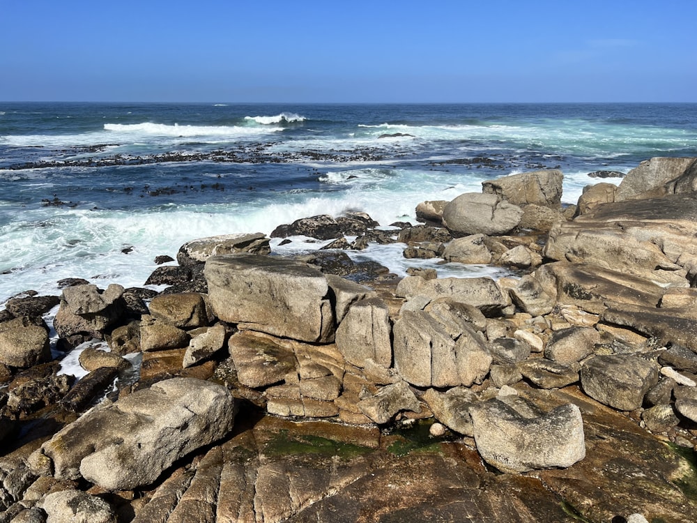 a rocky beach with waves coming in from the ocean