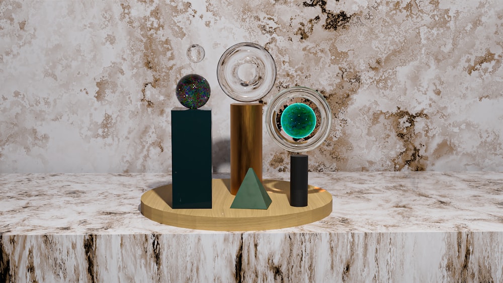 a marble table with a gold stand and three glass objects on it