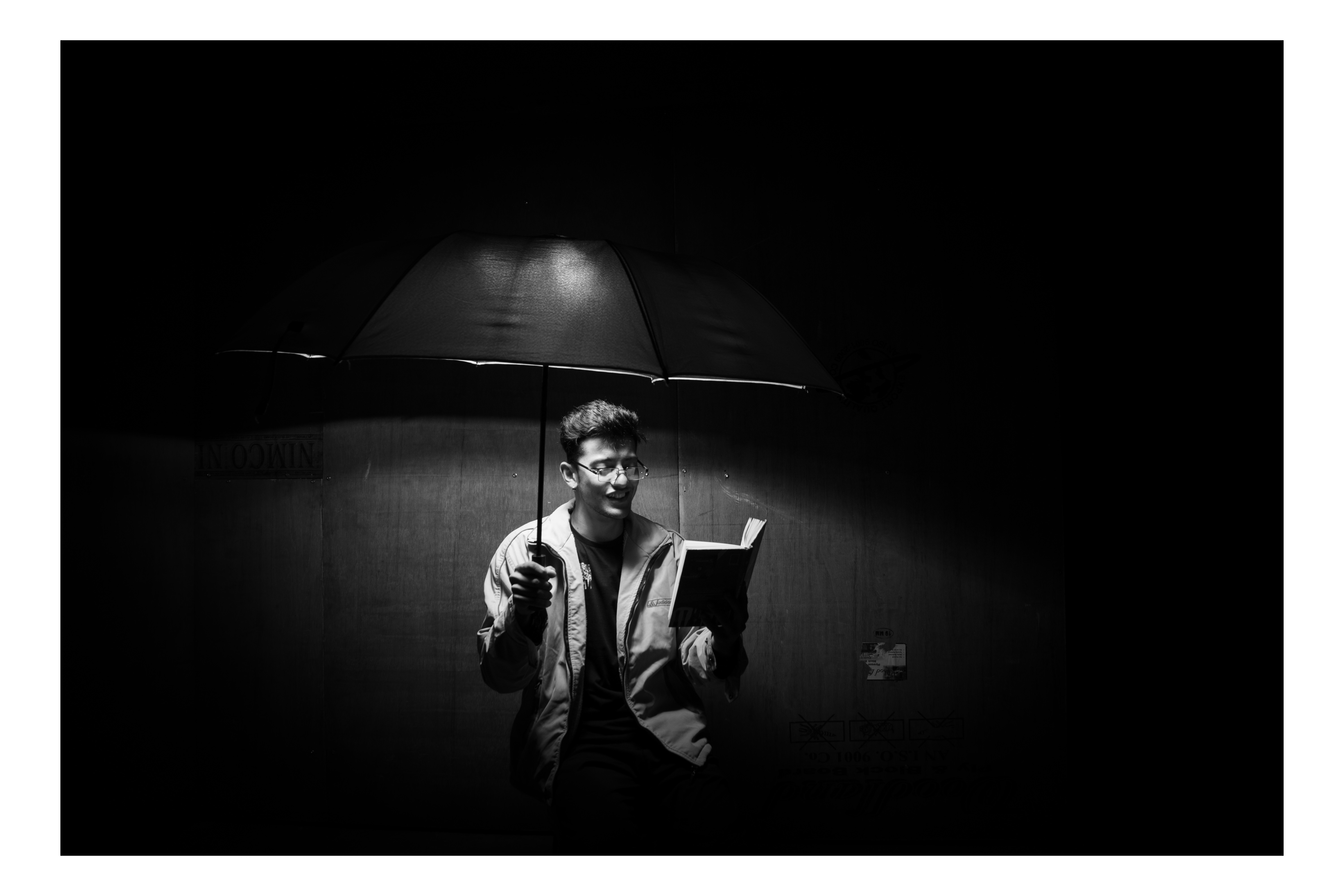 Man reading under a lamp at night