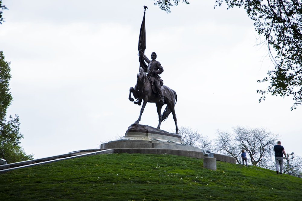 uma estátua de um homem em um cavalo segurando uma bandeira