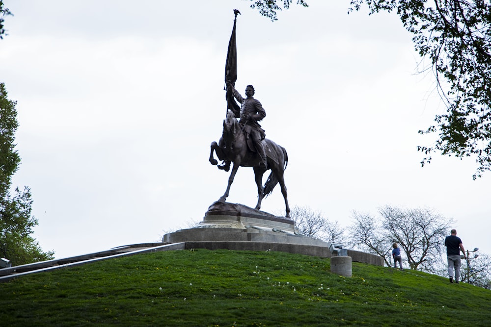 une statue d’un homme sur un cheval tenant un drapeau