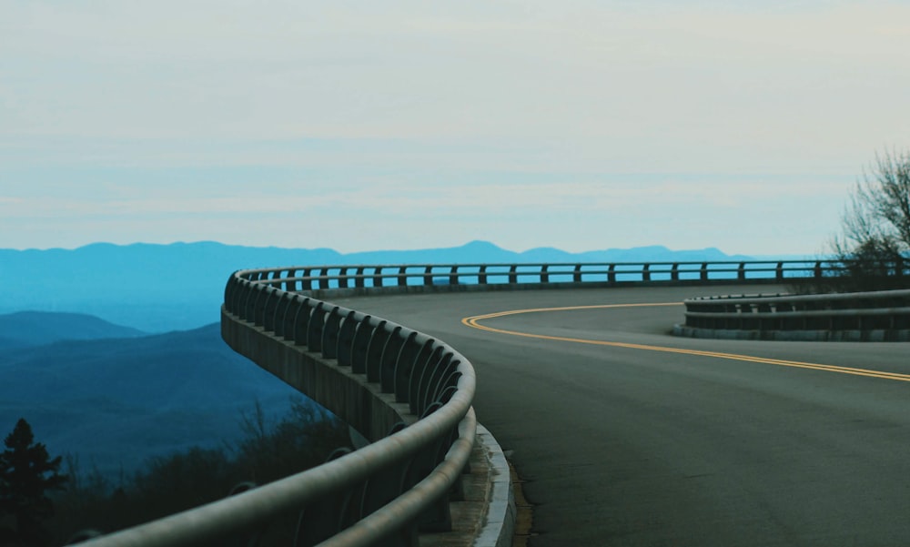 a curved road with a mountain in the background