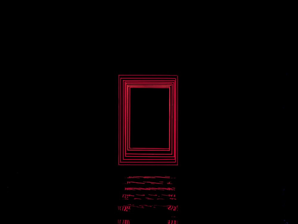 a dark room with a red door and a window