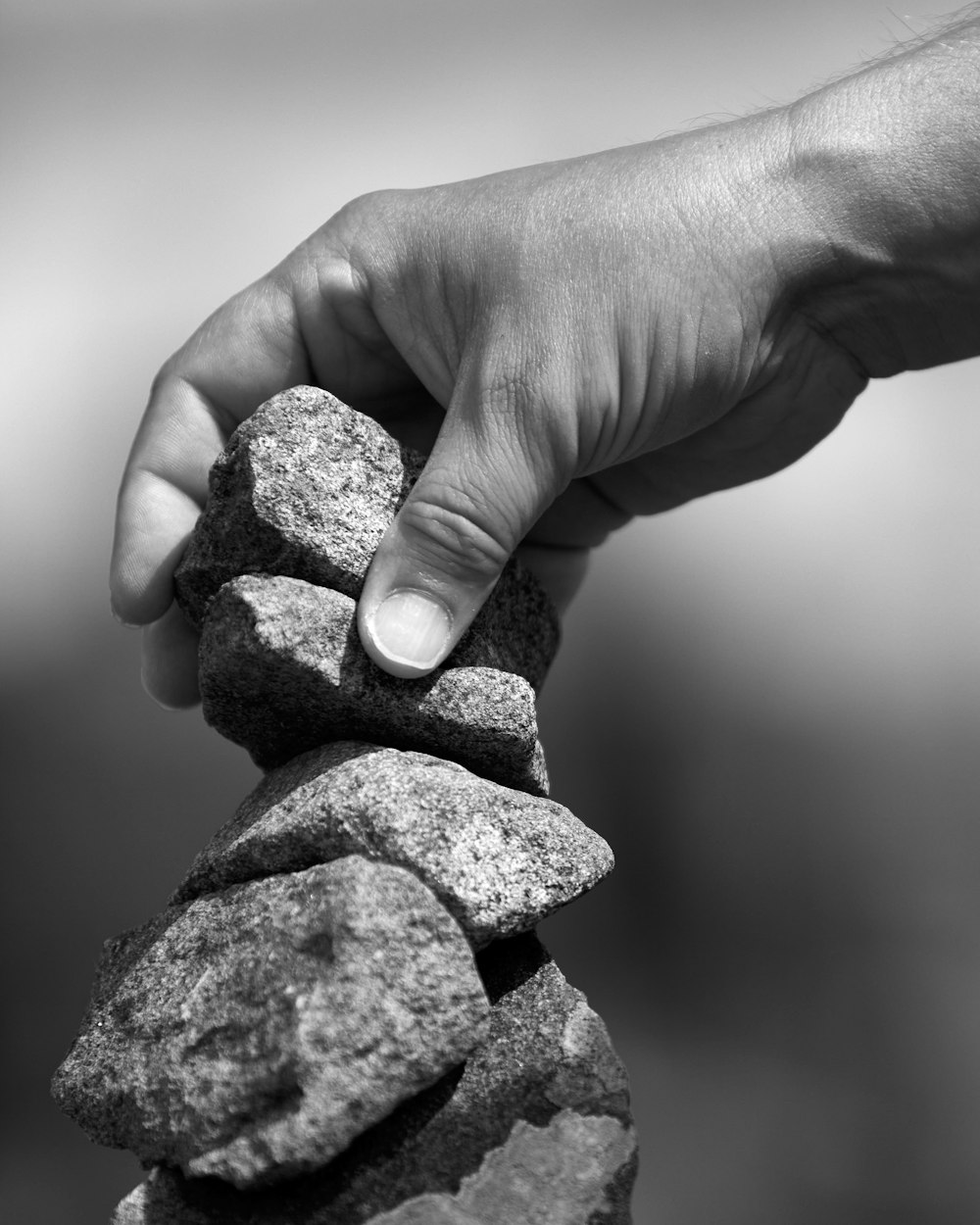 Una persona apilando rocas una encima de la otra