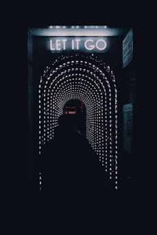 a dark tunnel with a sign that says let it go
