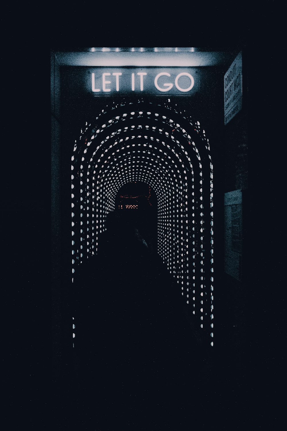 Un túnel oscuro con un letrero que dice Let It Go