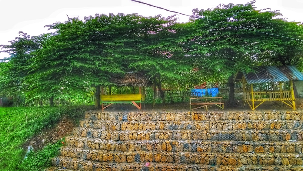 a large pile of hay sitting next to a lush green forest