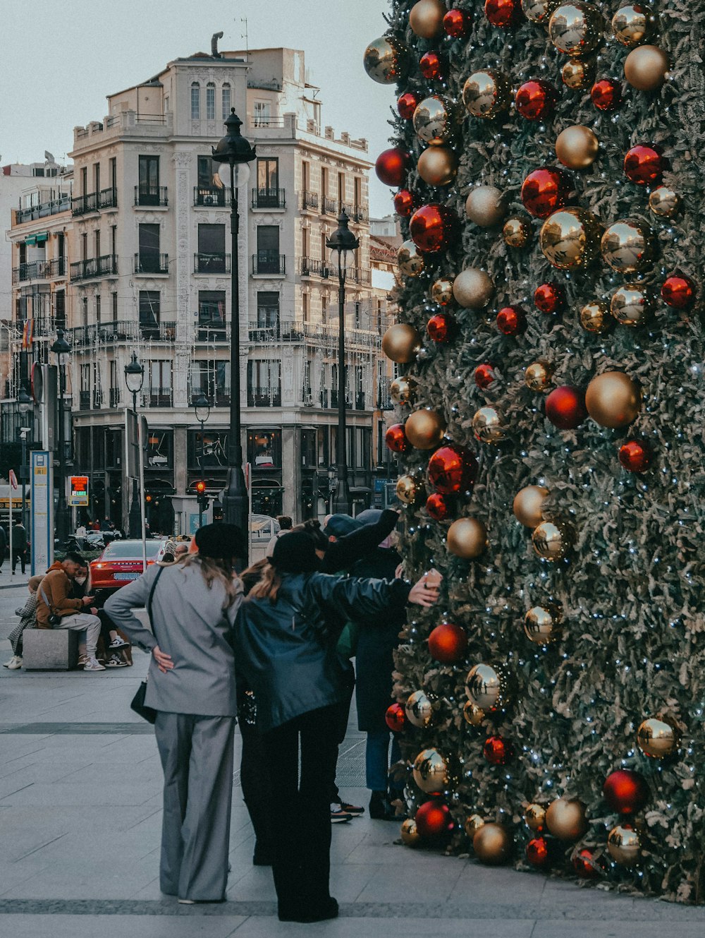 a group of people standing next to a christmas tree