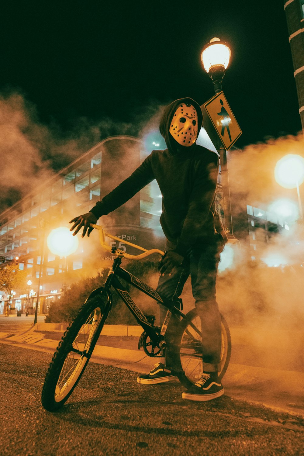 a person wearing a mask standing next to a bike
