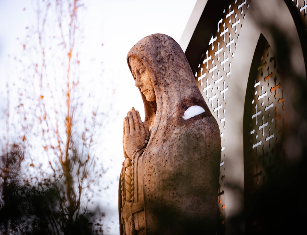 a statue of a woman with her hands together