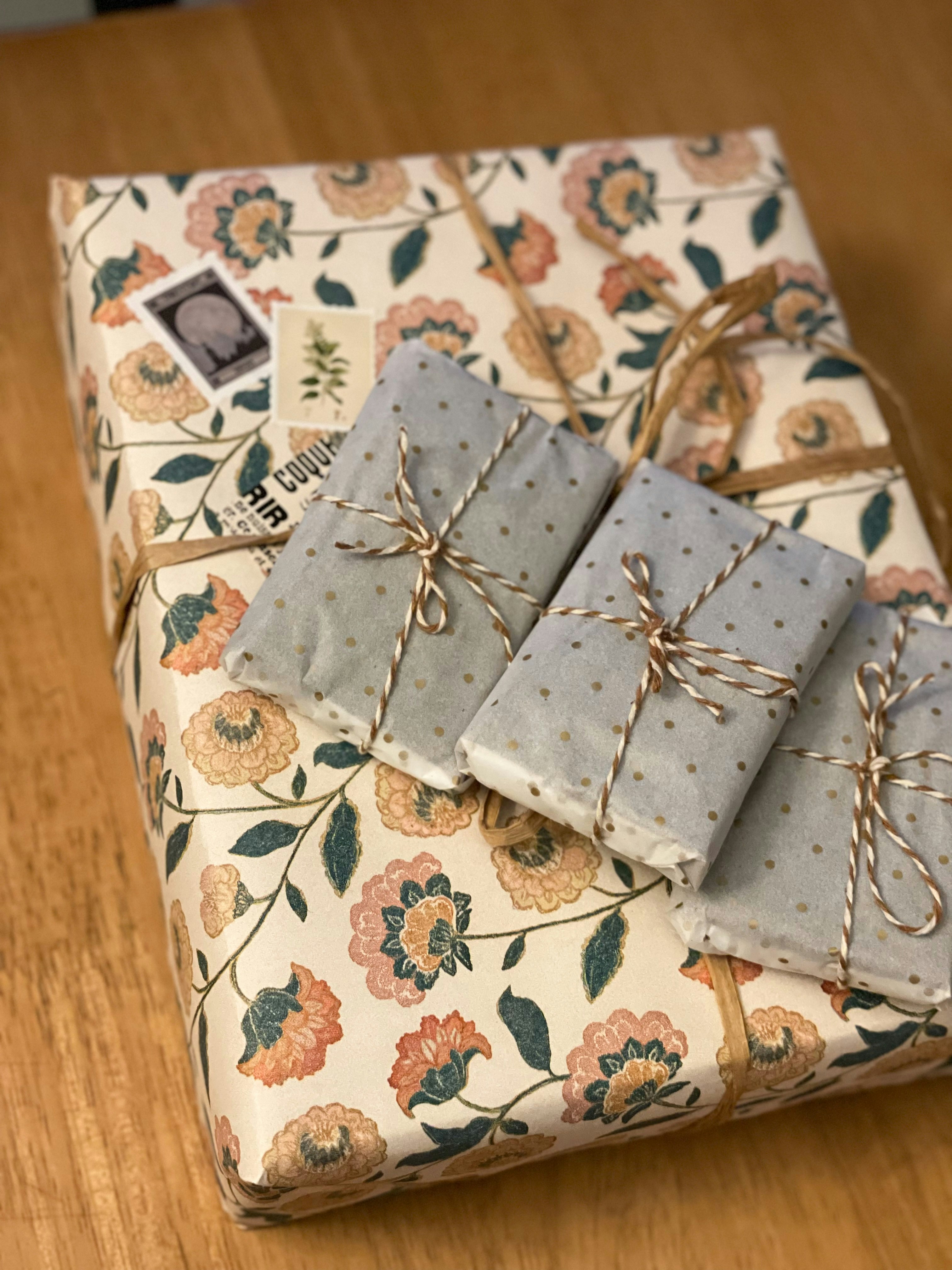 three wrapped presents sitting on top of a wooden table