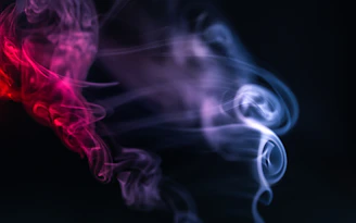 a red and purple smoke is shown against a black background
