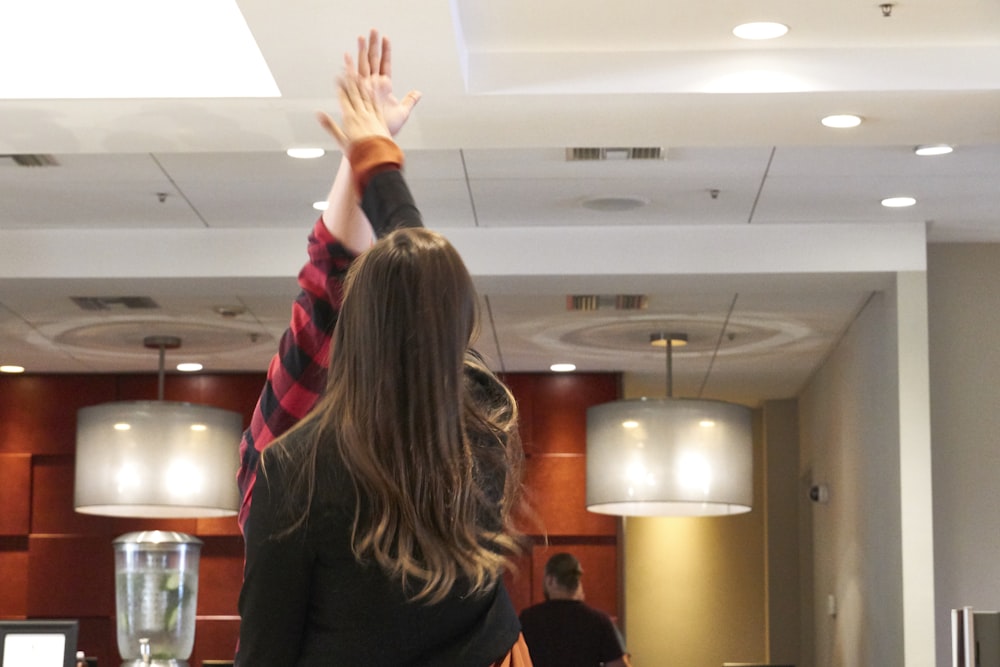 a woman reaching up to catch a frisbee