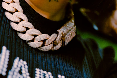 Close-up of a heavy, elegant imitation gold necklace set on a beige background.