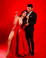 A candid moment of a woman laughing, wearing a bold red dress with subtle ruffles.