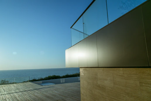 A sleek, modern office building in Monaco with the Mediterranean Sea in the background, symbolizing Riviera Nexus's connection to Brook Capital Partners.
