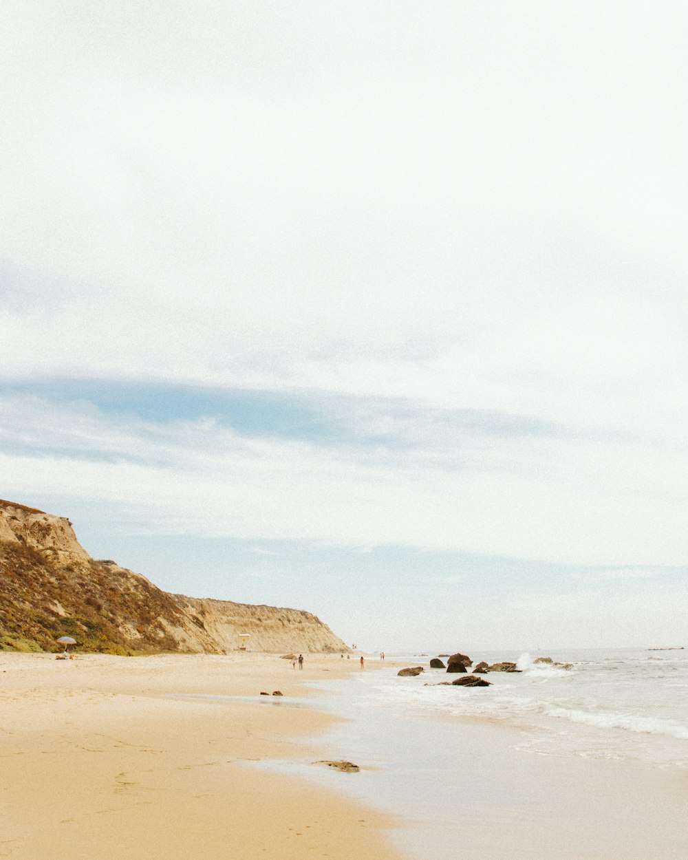 a person walking on a beach with a surfboard