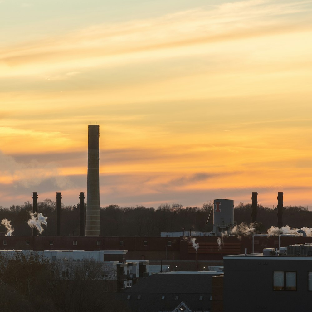 a factory with smoke stacks in the distance