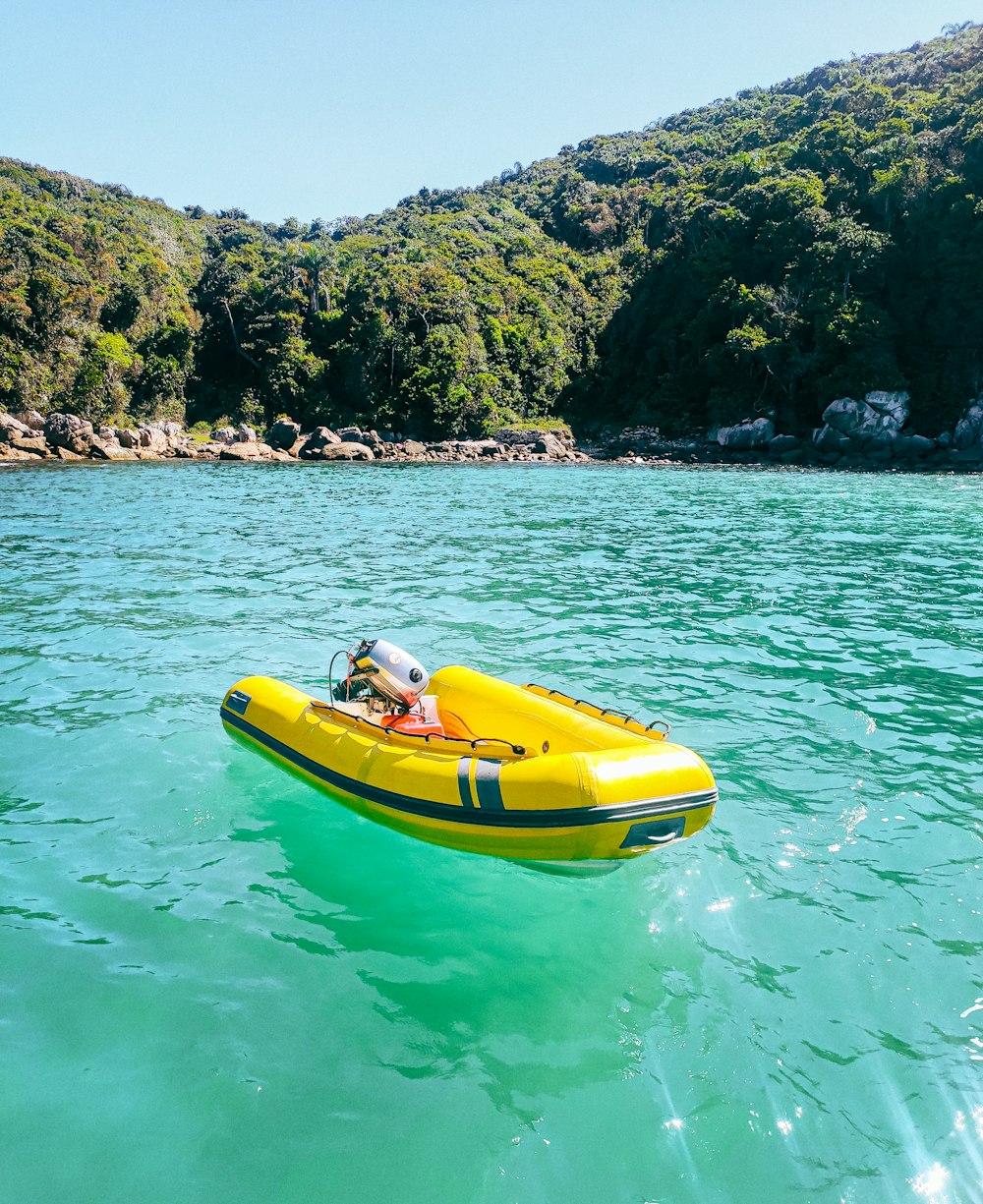 a yellow boat floating on top of a body of water