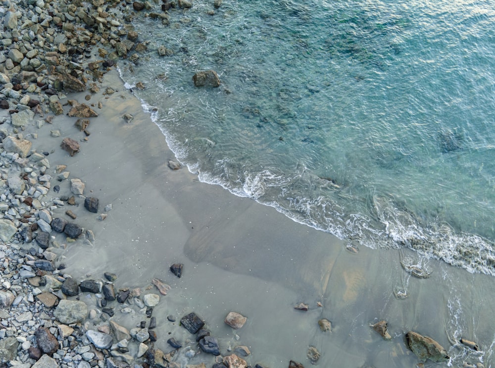 an aerial view of a beach with rocks and water